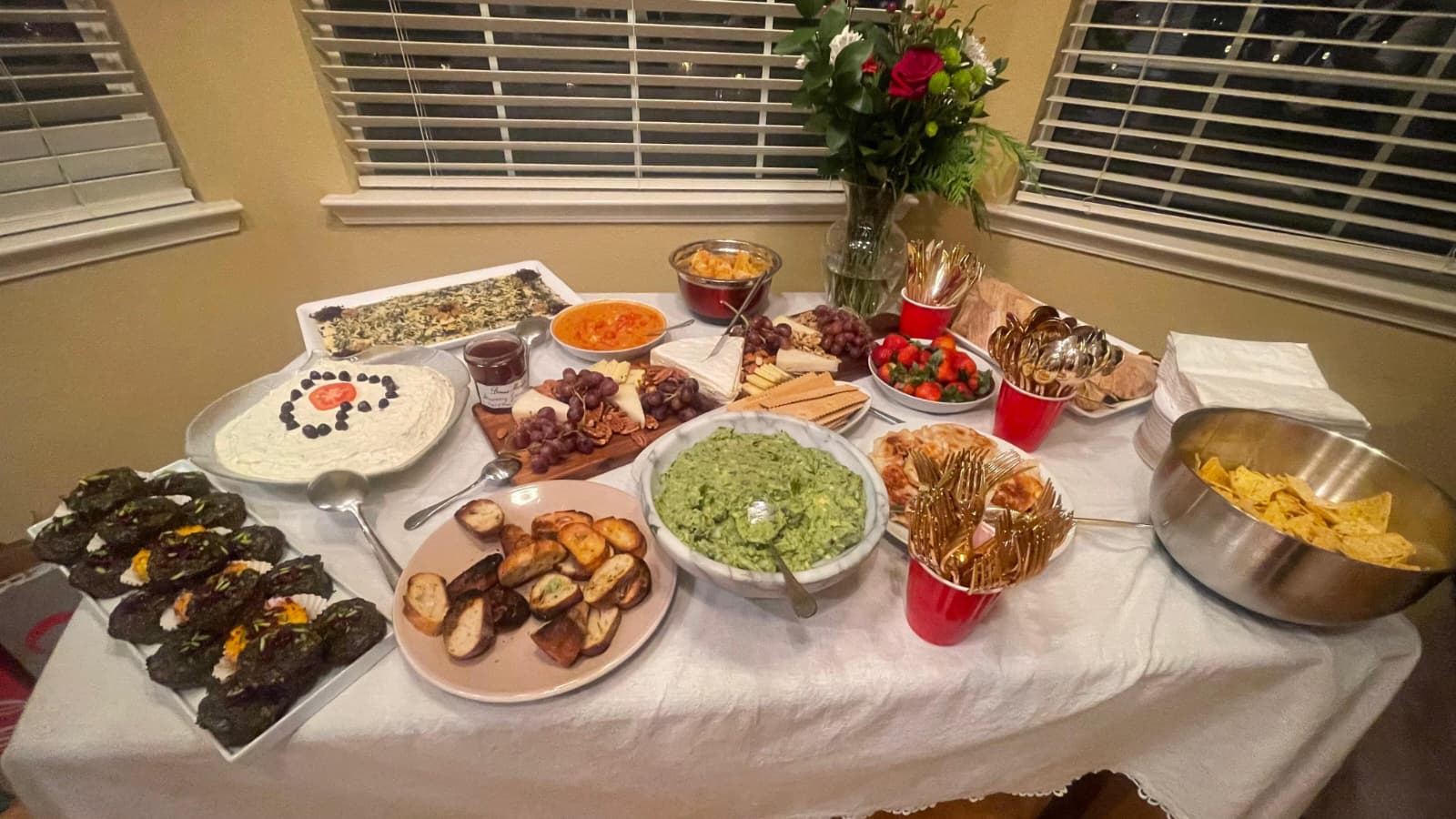 Mediterranean appetizer table with dips, bread, cheese and fruits